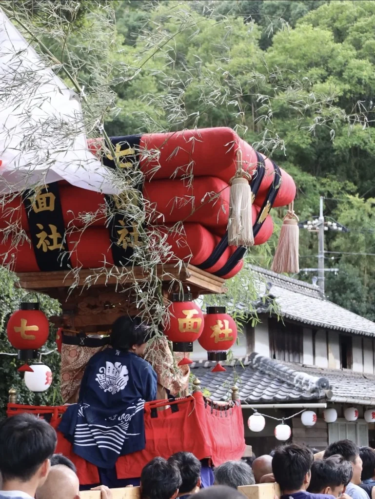 昼の光の中、笹の緑と朱色の布団屋根が間近に見える千歳楽