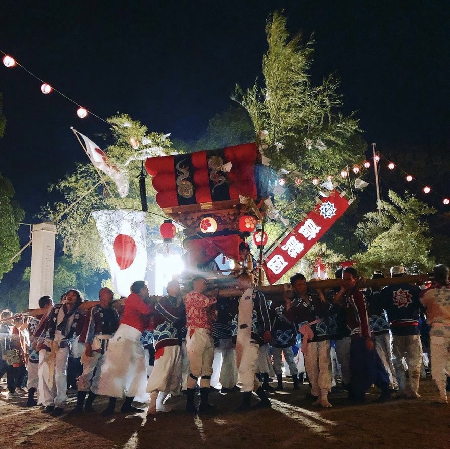 笹を立てた千歳楽が夜の境内を練り歩く