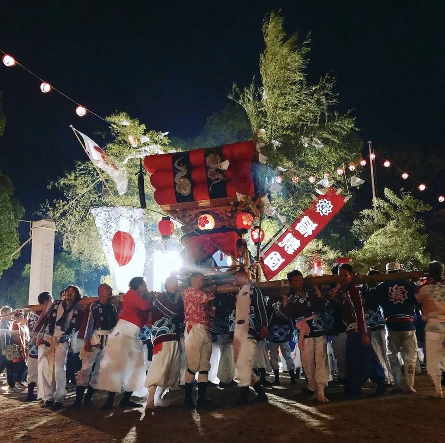 笹を立てた千歳楽が夜の境内を練り歩く
