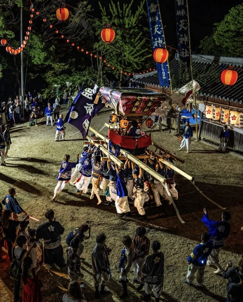 宵宮の夜、幟と提灯が連なる境内で担がれる千歳楽